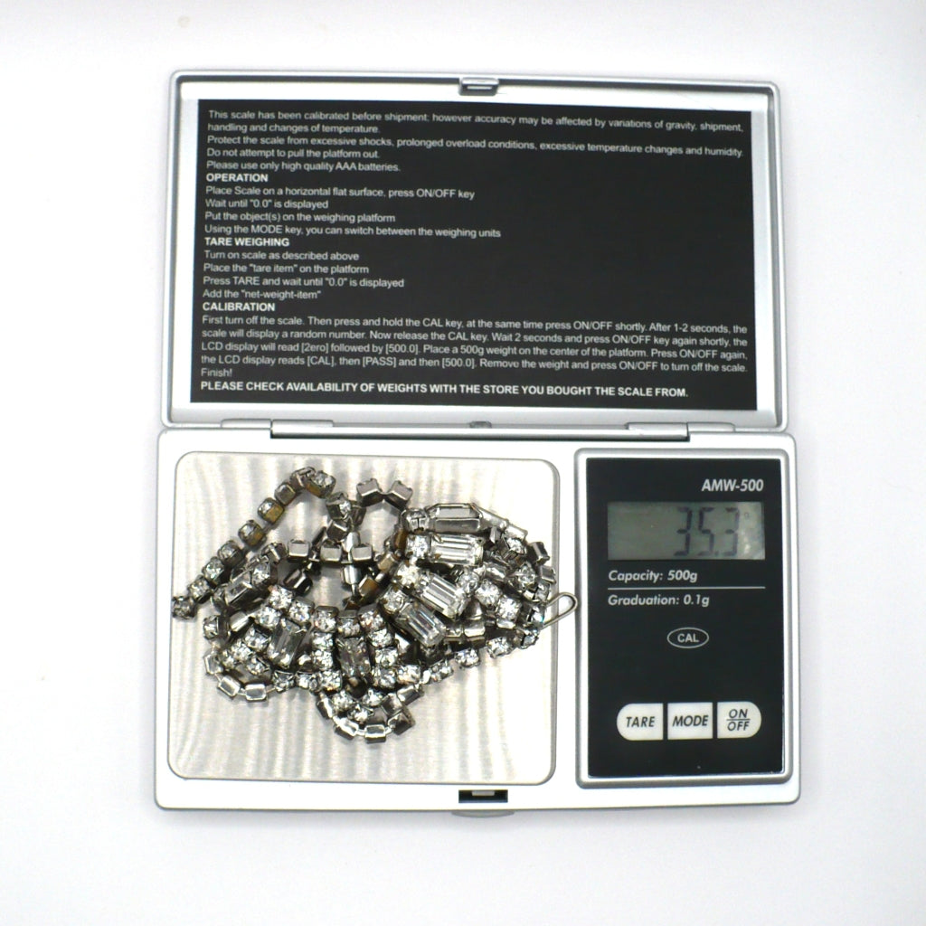 Signed vintage Lisner rhinestone festoon necklace on a digital scale showing a weight of 35.3 grams.