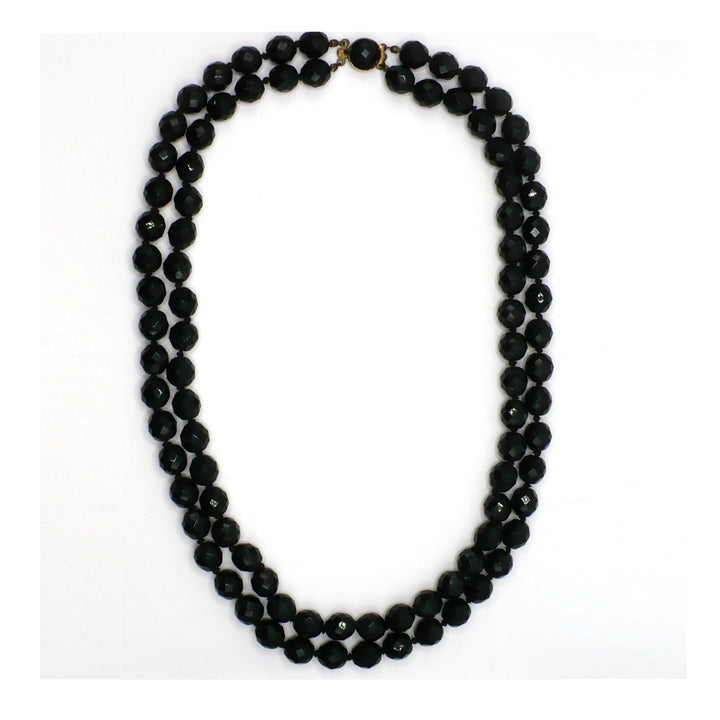 1950s vintage multi-strand black faceted glass bead necklace with a gold-toned ornamental box clasp.