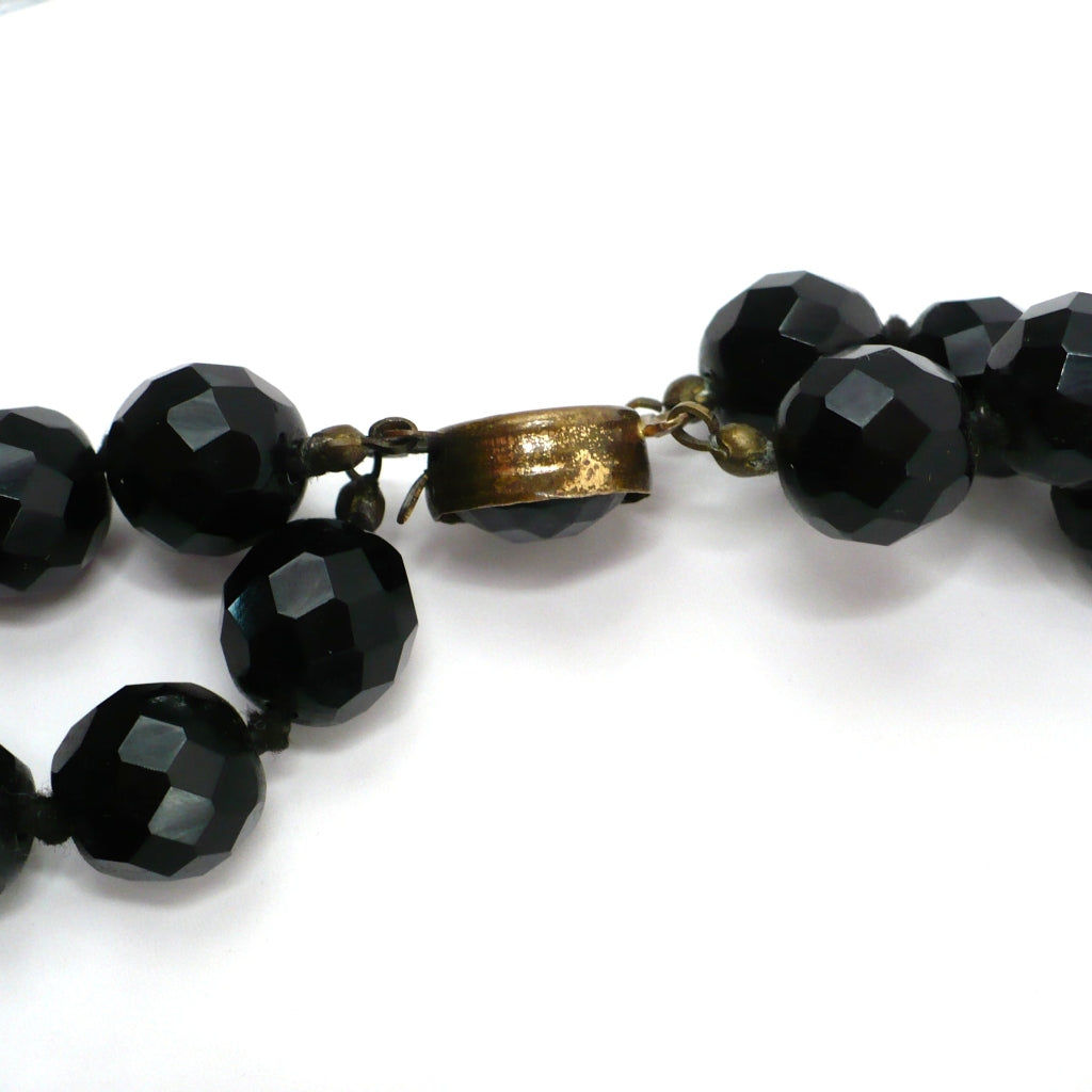 1950s vintage multi-strand black faceted glass bead necklace with a gold-toned ornamental box clasp side view.