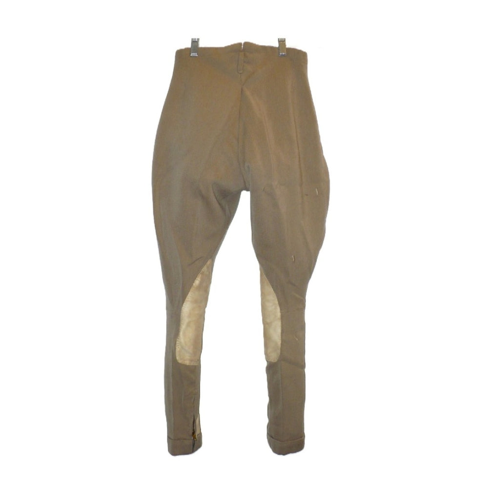A pair of children's vintage equestrian breeches in a muted taupe-brown color, featuring light beige leather knee patches and matching ankle patches, shown hanging against a plain white background, back view.