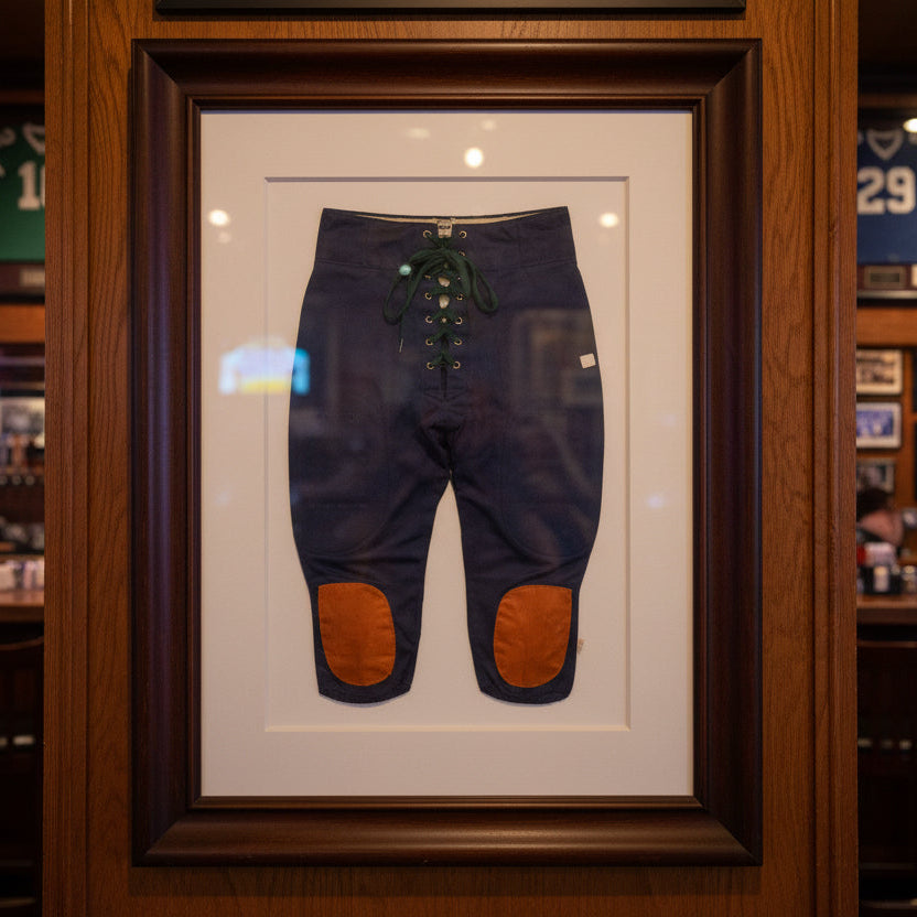 Framed vintage football pants on display in a store setting