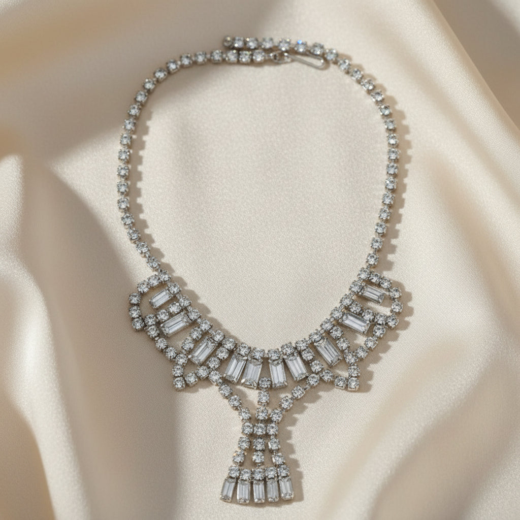 1950s Vintage Art Deco Rhinestone Festoon Necklace front view on creamy silk fabric.