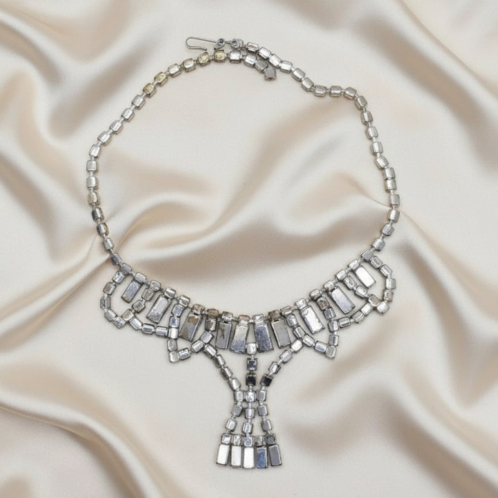 1950s Vintage Art Deco Rhinestone Festoon Necklace back view on creamy silk fabric, shows silver-tone plating loss. on back.