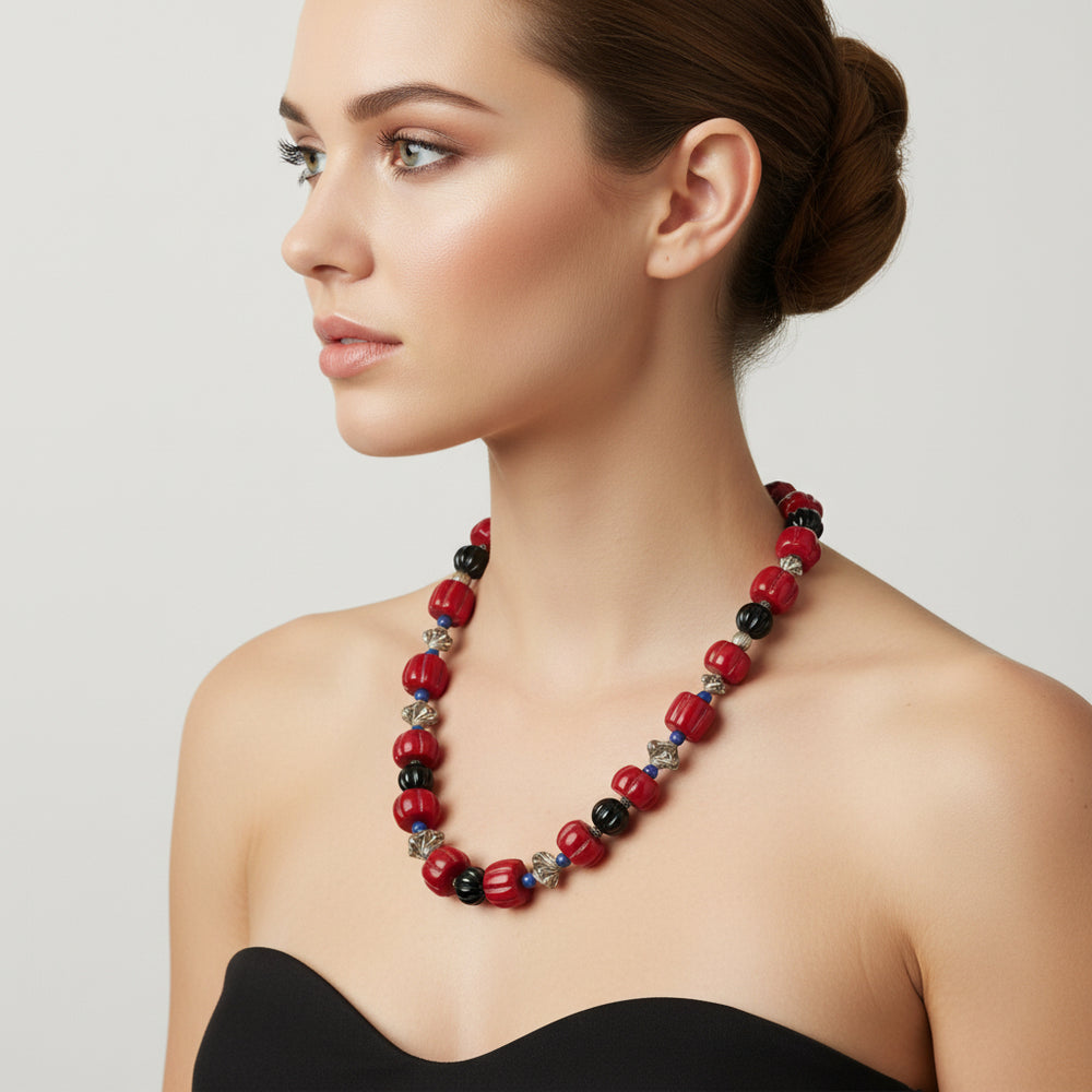 Necklace with red coral, black onyx, lapis, and silver beads on a woman.