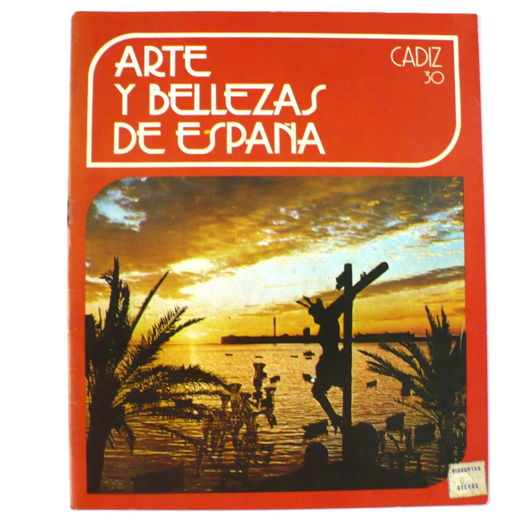 Cover of the booklet 'Arte Y Bellezas De España Volumen 30 Cadiz' featuring a colorful sunset over a body of water with a cross and palm trees in the foreground.