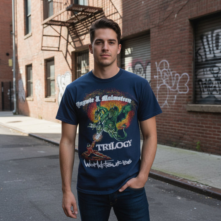 Man wearing a blue 86-87 Vintage Yngwie Malmsteen Trilogy Tour T-Shirt, standing on a street.