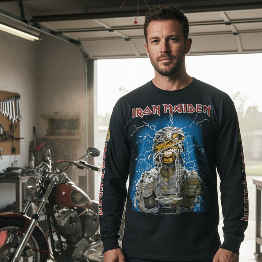 Man wearing an Iron Maiden long-sleeve shirt in a garage with a motorcycle.