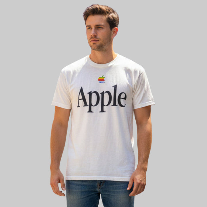 Man wearing a white t-shirt with 'Apple' logo on a plain background