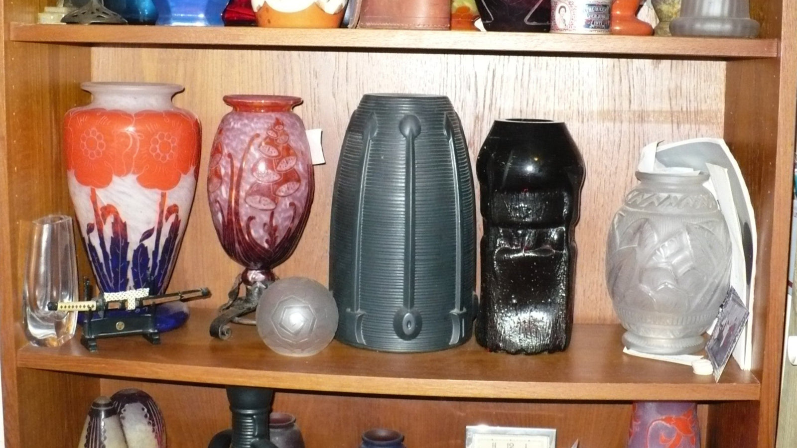 Collection of decorative vases on a wooden shelf: small segment of the art glass we are listing right now.