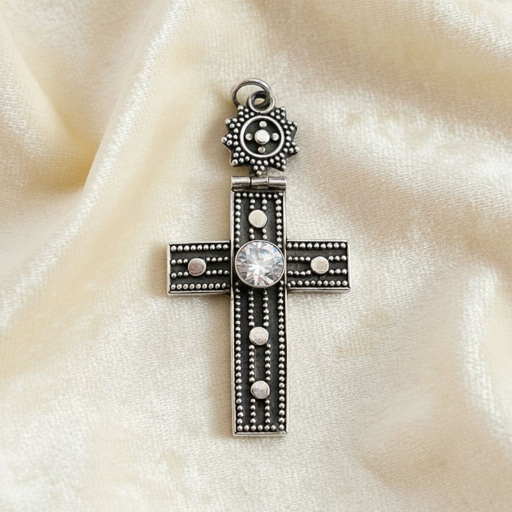 Vintage 1980s Mayan-Inspired Oxidized Cross Pendant with Cubic Zirconia Stone on plain background.