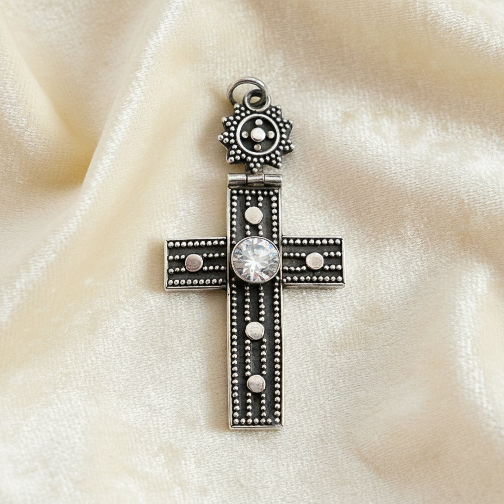 Vintage 1980s Mayan-Inspired Oxidized Cross Pendant with Cubic Zirconia Stone on plain background.