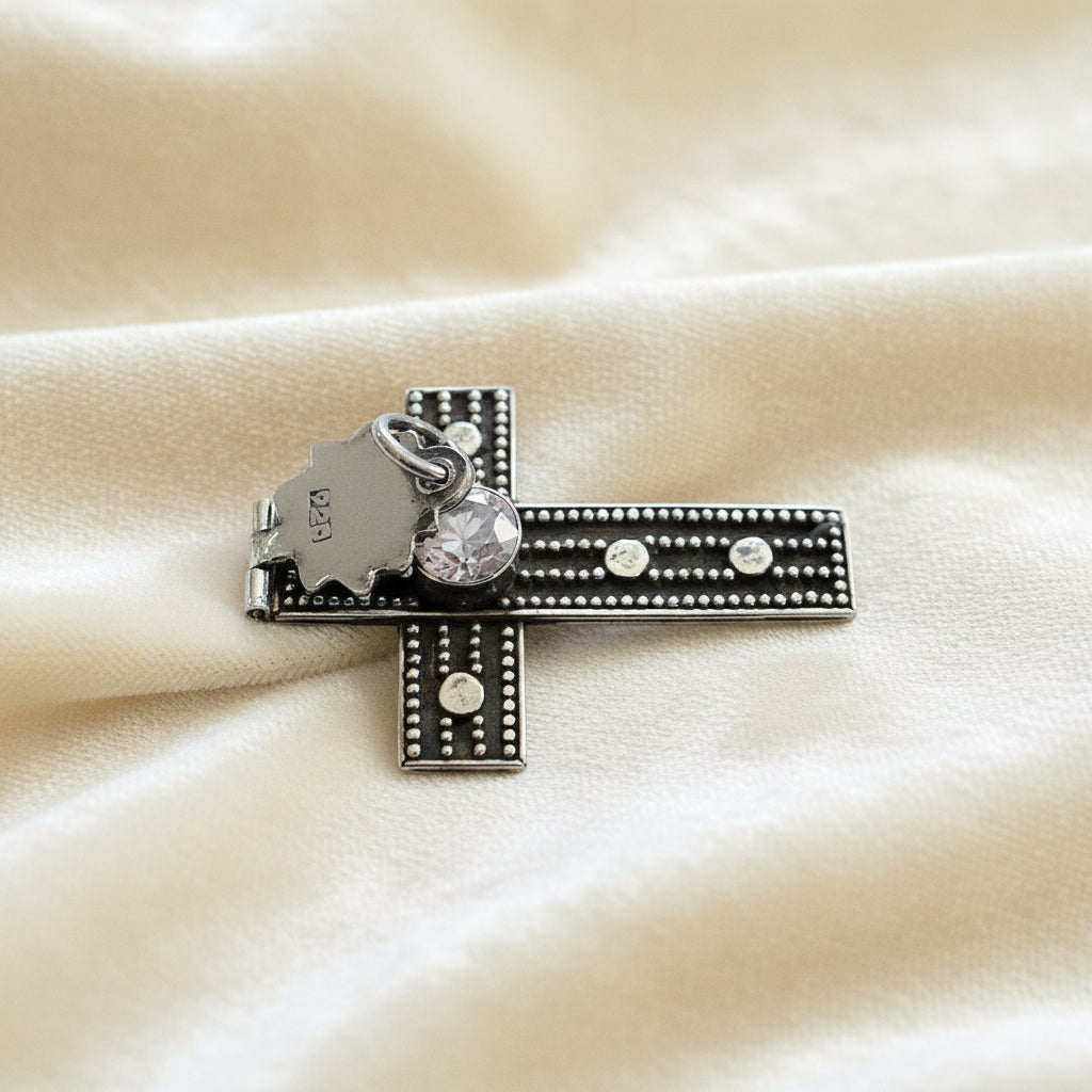 Vintage 1980s Mayan-Inspired Oxidized Cross Pendant with Cubic Zirconia Stone on plain background. Showing hinged top and 925 hallmark on the back