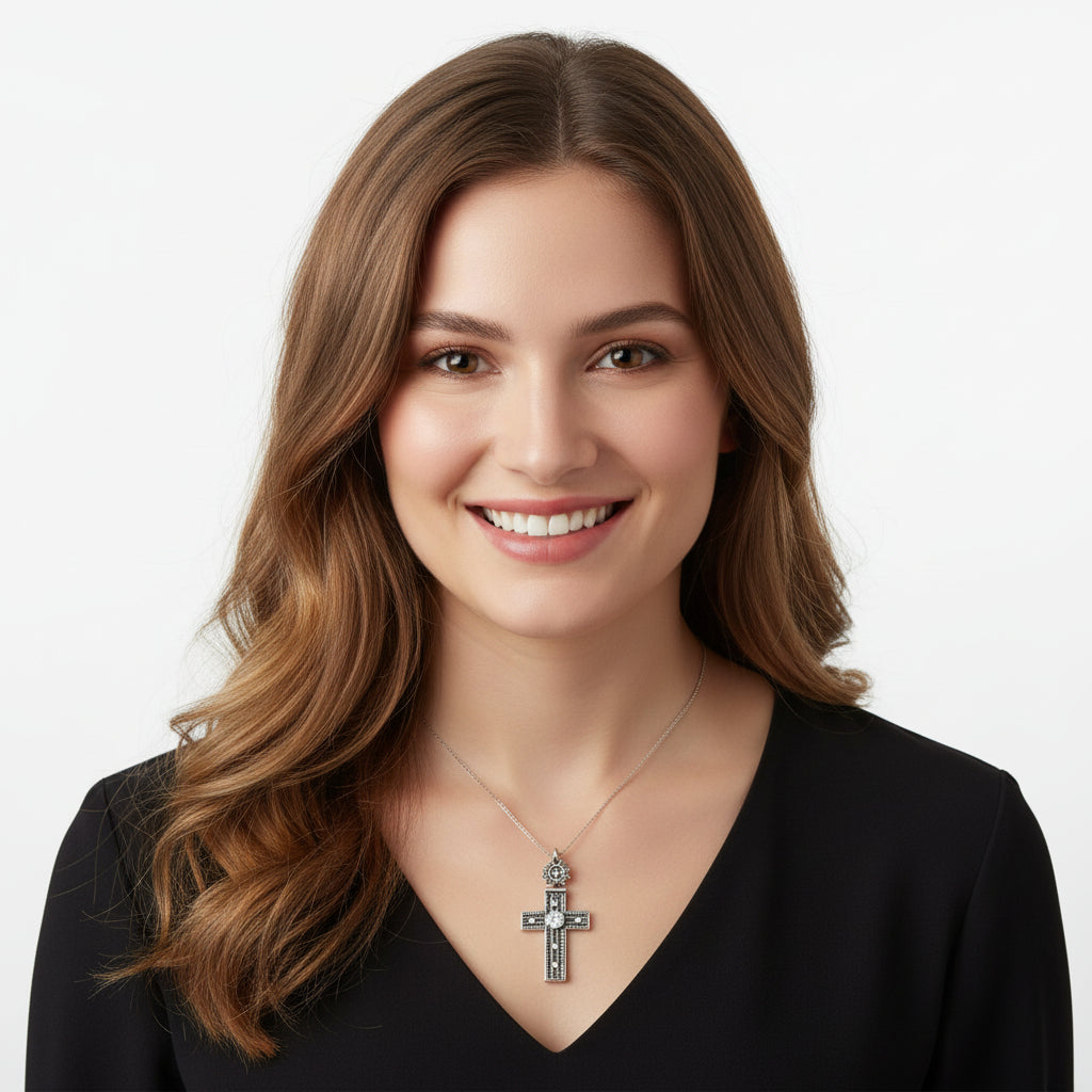 Vintage 1980s Mayan-Inspired Oxidized Cross Pendant with Cubic Zirconia Stone on plain background. Woman is wearing it.