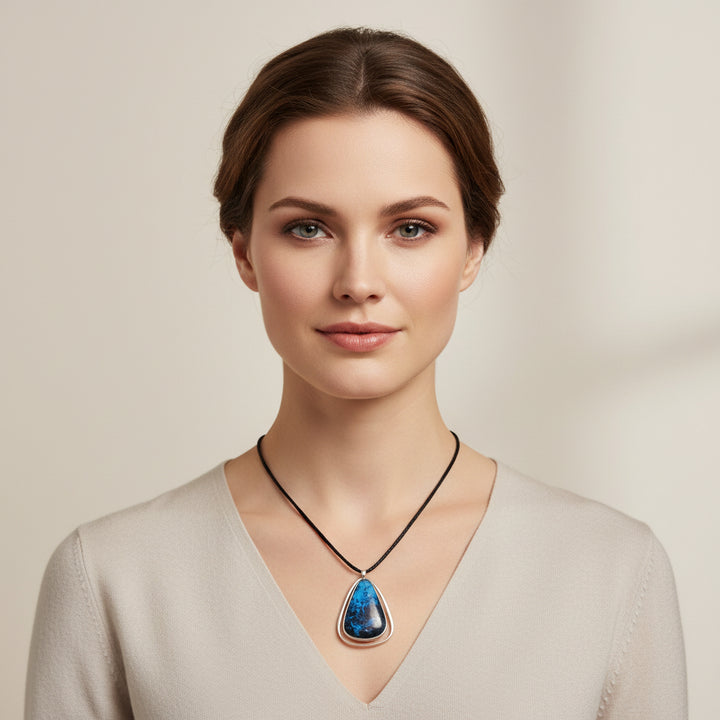 Frances Holmes Boothby Modernist Kinetic Dumortierite Sterling Pendant worn by a woman with plain background.