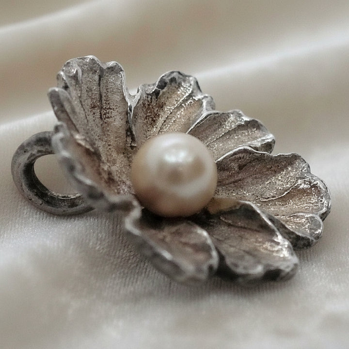 Silver Flower and Pearl Pendant on velvet ground.