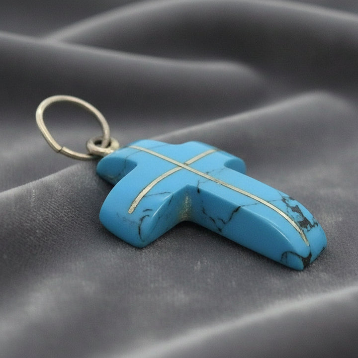 Blue Howlite cross pendant on gray background.
