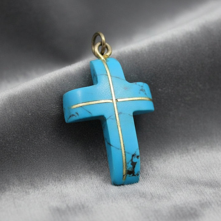 Blue Howlite cross pendant on gray background.