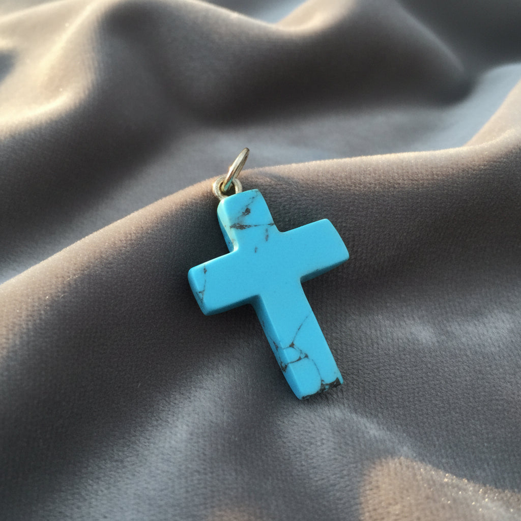 Blue Howlite cross pendant on gray background.