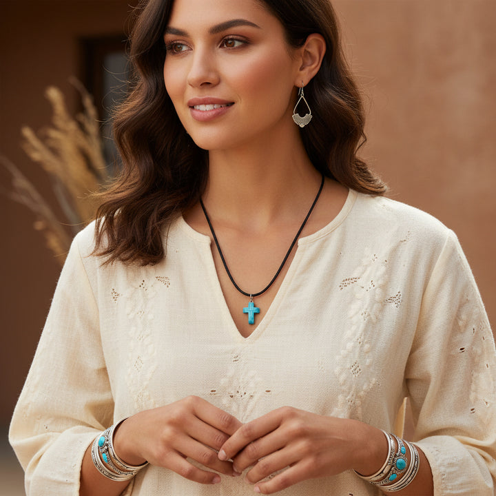 Woman wearing a necklace with a cross pendant in a warm-toned setting