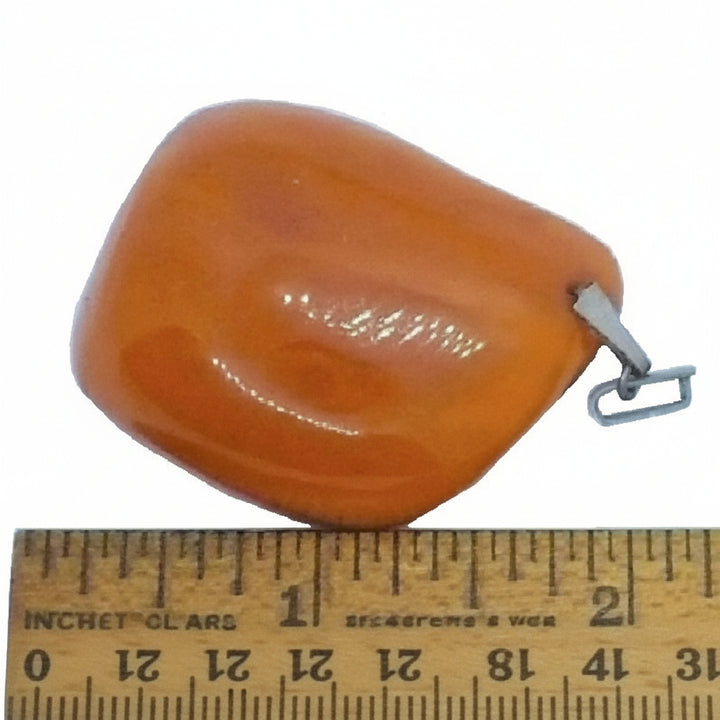Large 1950s Vintage Soviet Baltic Amber Pendant next to wooden ruler.