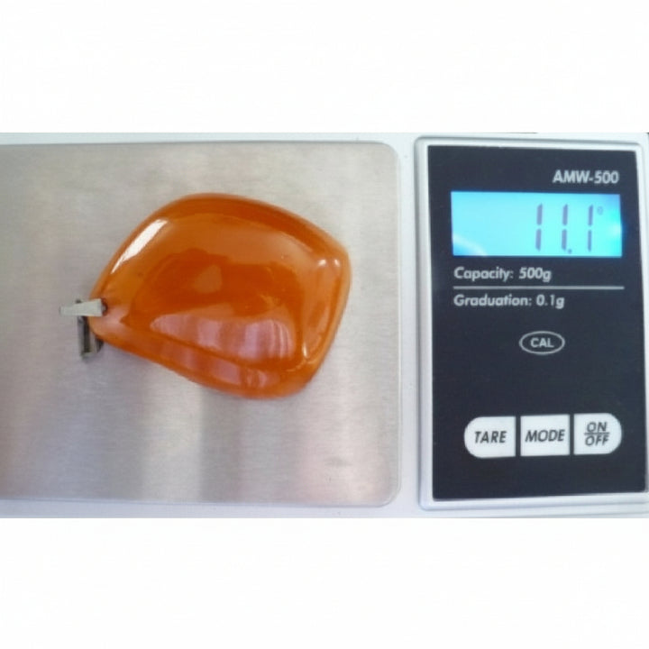 1950s Soviet Era Butterscotch Amber Pendant on  jewelry scale verifying weight as 11.1 grams.