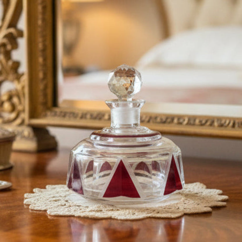 1930s Red Art Deco Palda Cologne or Perfume Bottle on a wooden surface, blurred mirror in the background