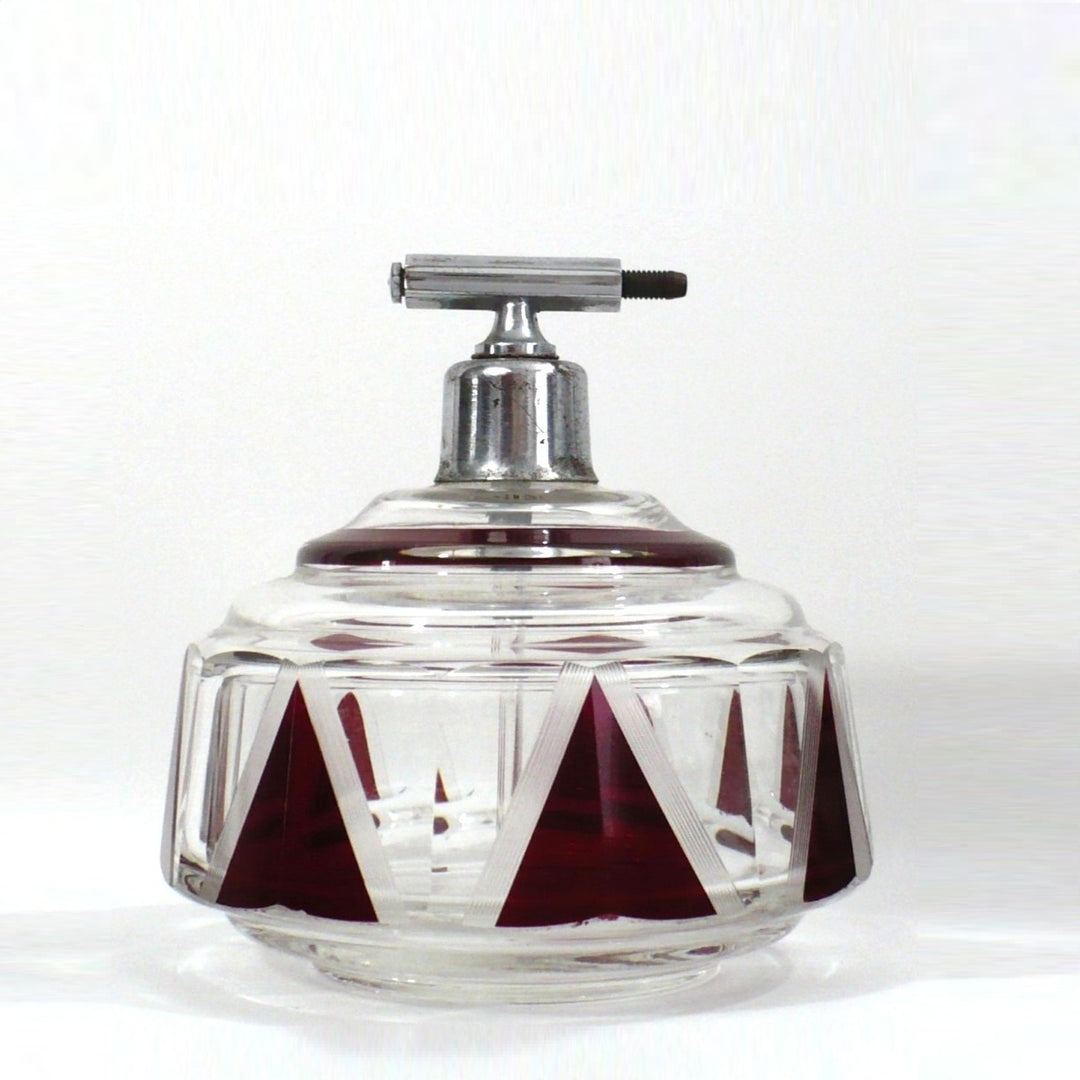 Karl Palda Art Deco perfume bottle atomizer with a metal top and red and clear geometric crystal body.
