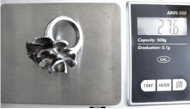 Brutalist ring on jewelry scale shows weight is 27.6 grams.