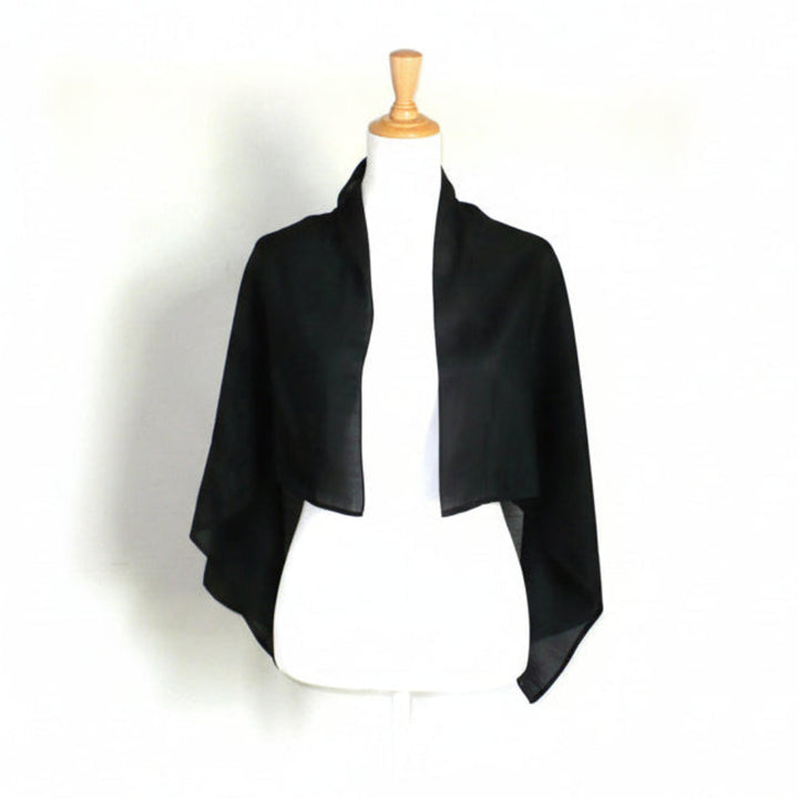 1800s Victorian black glazed cotton mourning scarf draped on a white dress form torso.