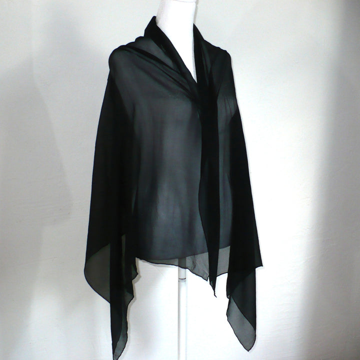 Black scarf on a mannequin against a white background.