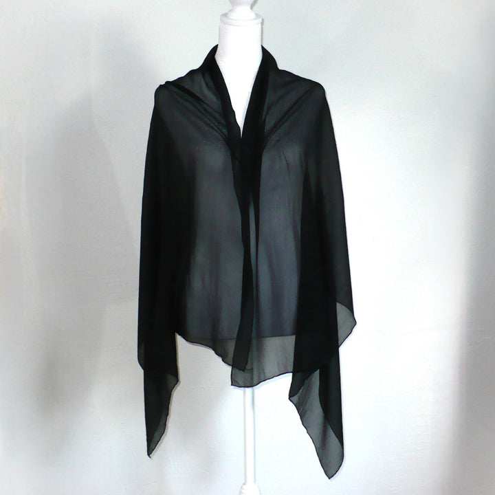 Black scarf on a mannequin against a white background.