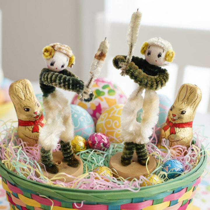 Decorative Easter scene with 1950s Japan Pipe Cleaner Baseball or Cricket Dolls – Vintage Sports Bendy Dolls and colorful eggs in a basket.