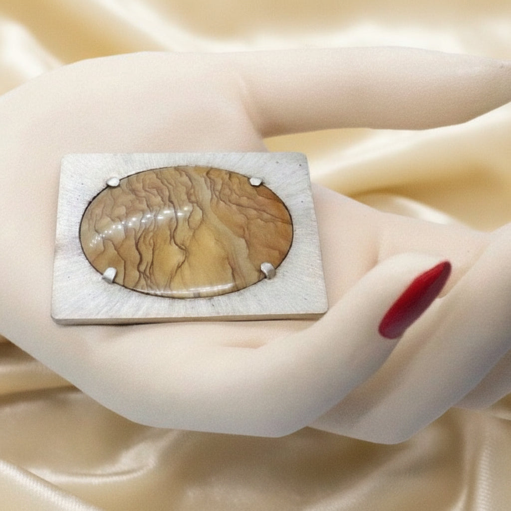 Transformable pendant and brooch in hand.