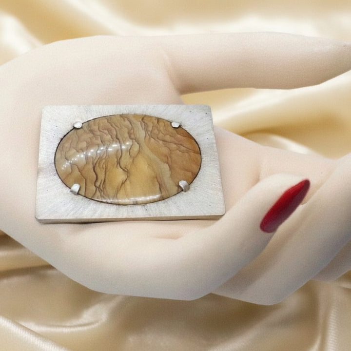 Transformable pendant and brooch in hand.