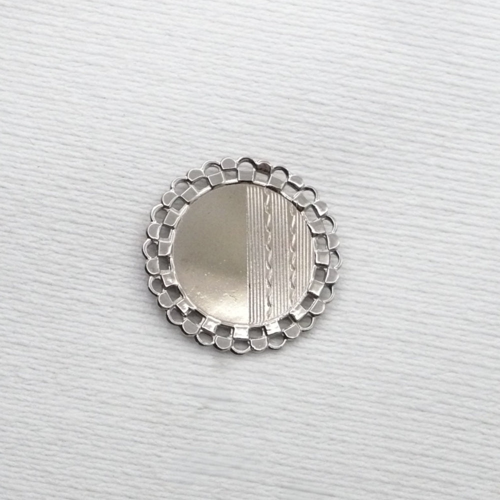 Silver decorative object on a textured white background