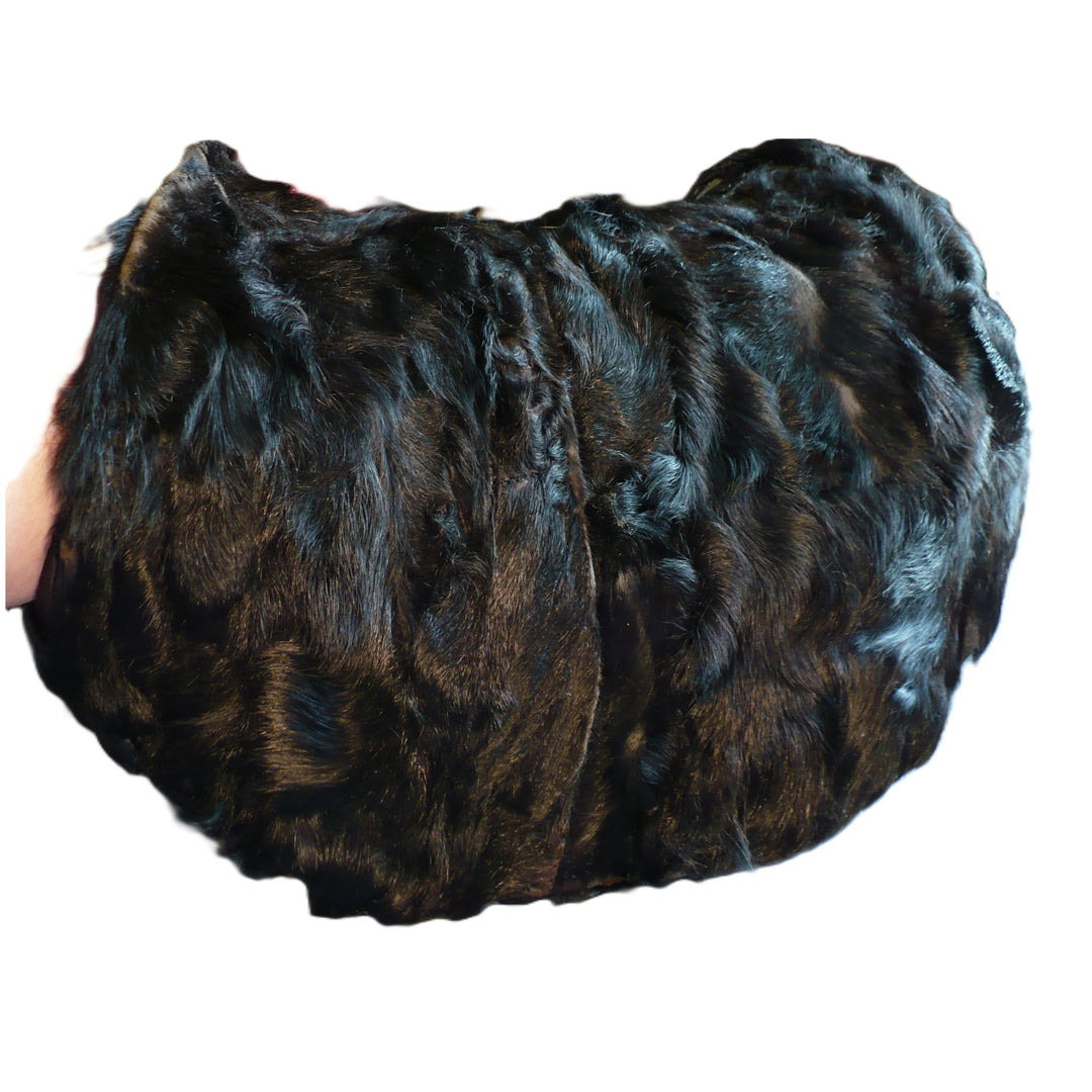 Vintage 1960s black broadtail lamb fur muff handbag showing the rich, watered-silk moiré texture against a white background.