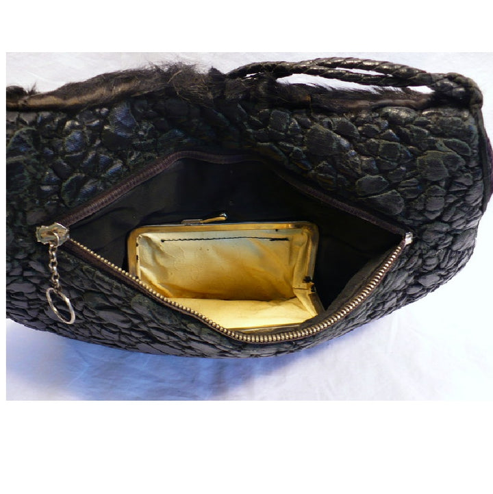 Interior view of the 1960s black broadtail lamb muff handbag showing the open zipper compartment and the opened, kiss-clasp coin purse.