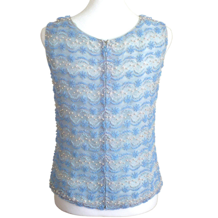 Back view of small 1960s Vintage Periwinkle Blue Beaded Shell Cocktail Top Shirt on a dress form with plain background.