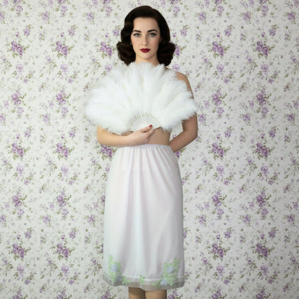 Woman in a 60s Vintage Applique Nylon Half Slip by Van Raalte Made in USA, XS. with a feathered shawl against a floral wallpaper background