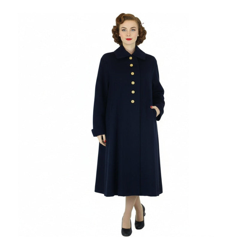 Woman wearing a long navy coat on a white background,