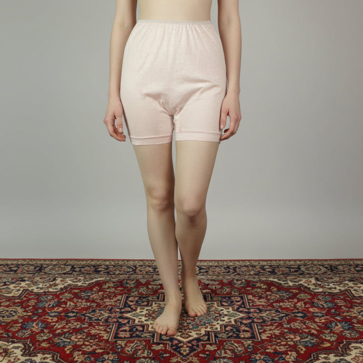 Woman wearing1930s Vintage Cotton Flannel Long Leg Snuggies Panties Boxers. on a patterned rug with a plain background