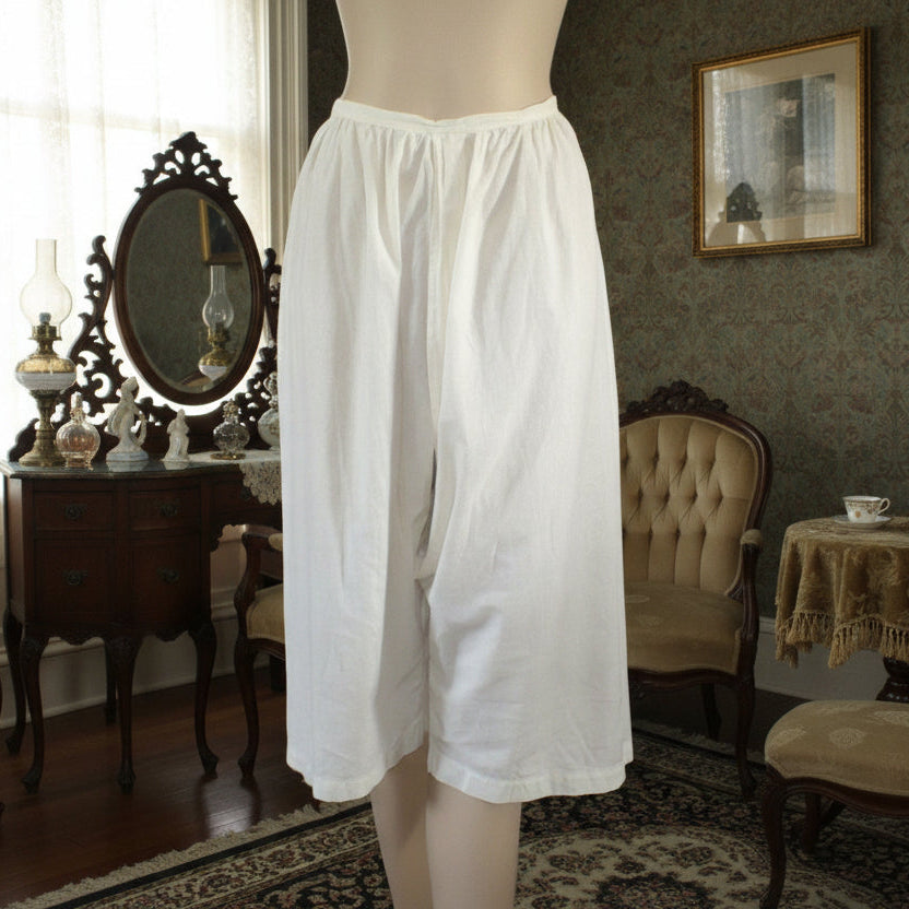 White split crotch bloomers displayed on a mannequin in an elegant room with furniture and decor.