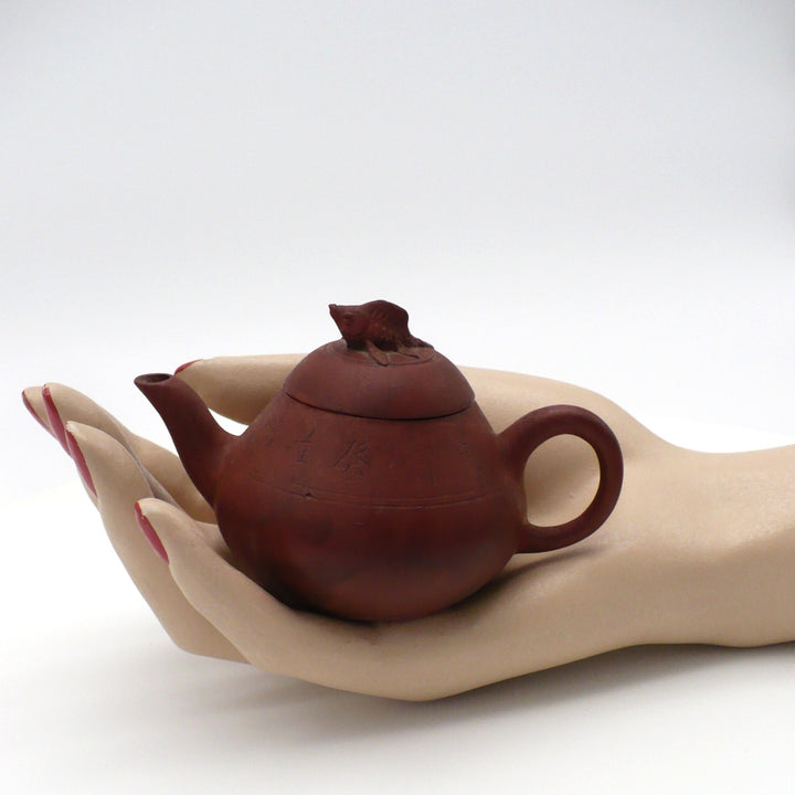 Late Qing Chaozhou Red Clay Teapot  in a mannequin hand for scale.