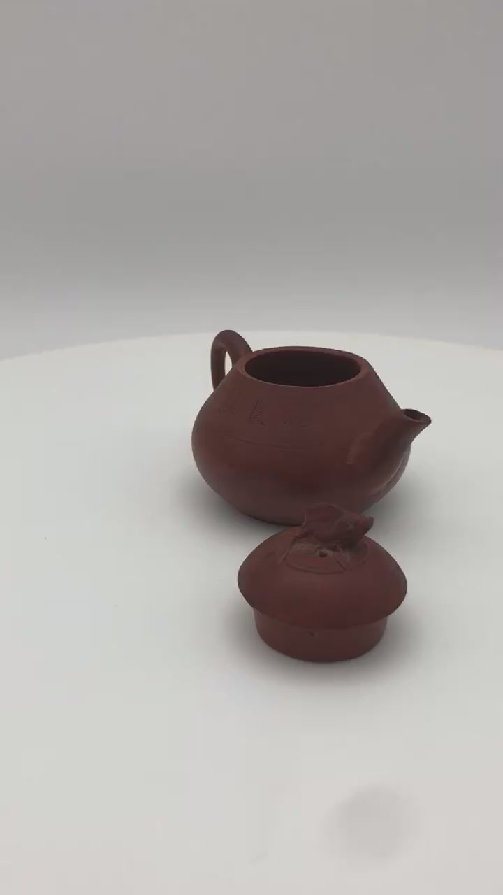 Late Qing Chaozhou Red Clay Teapot  with lid off and seen to the side, on a rotating platform.