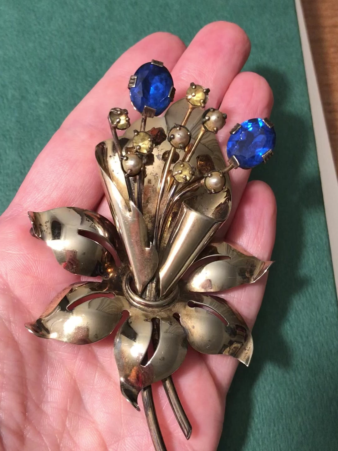 Video of brooch in a hand showingth ethree dimensional quality and color of the piece.